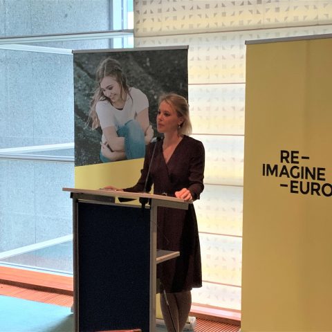 Erika Widegren delivering a speech with RIE logo in the background
