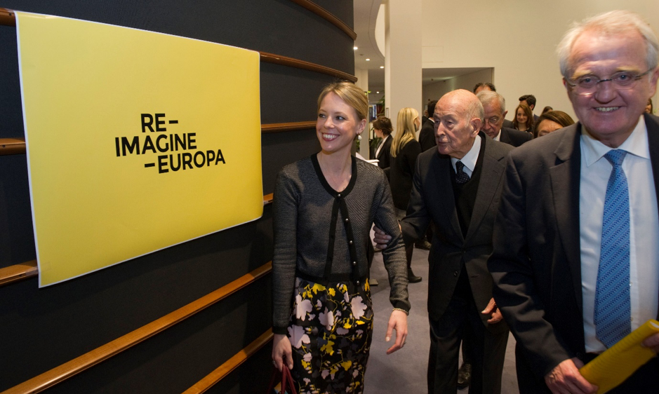 Photo of Erika Widegren and Giscard d'Estaign looking to a poster with RIE logo
