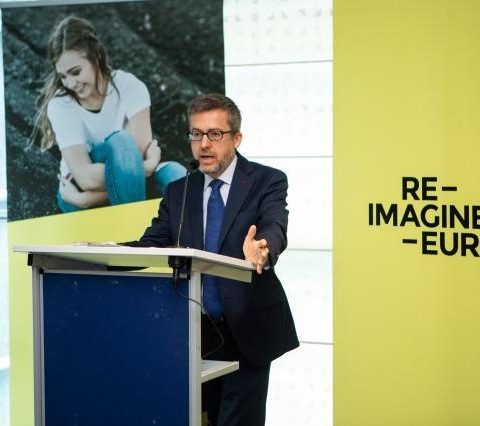 Carlos Moedas delivering a speech with RIE logo in the background