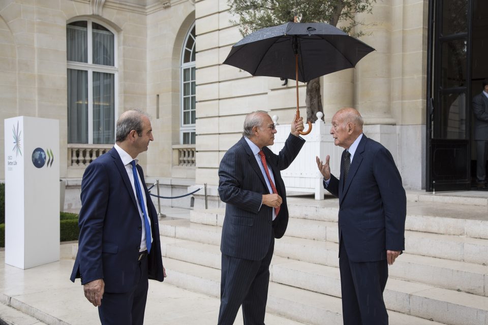 Giscard d'Estaing speaking with two men at the OECD headquarters
