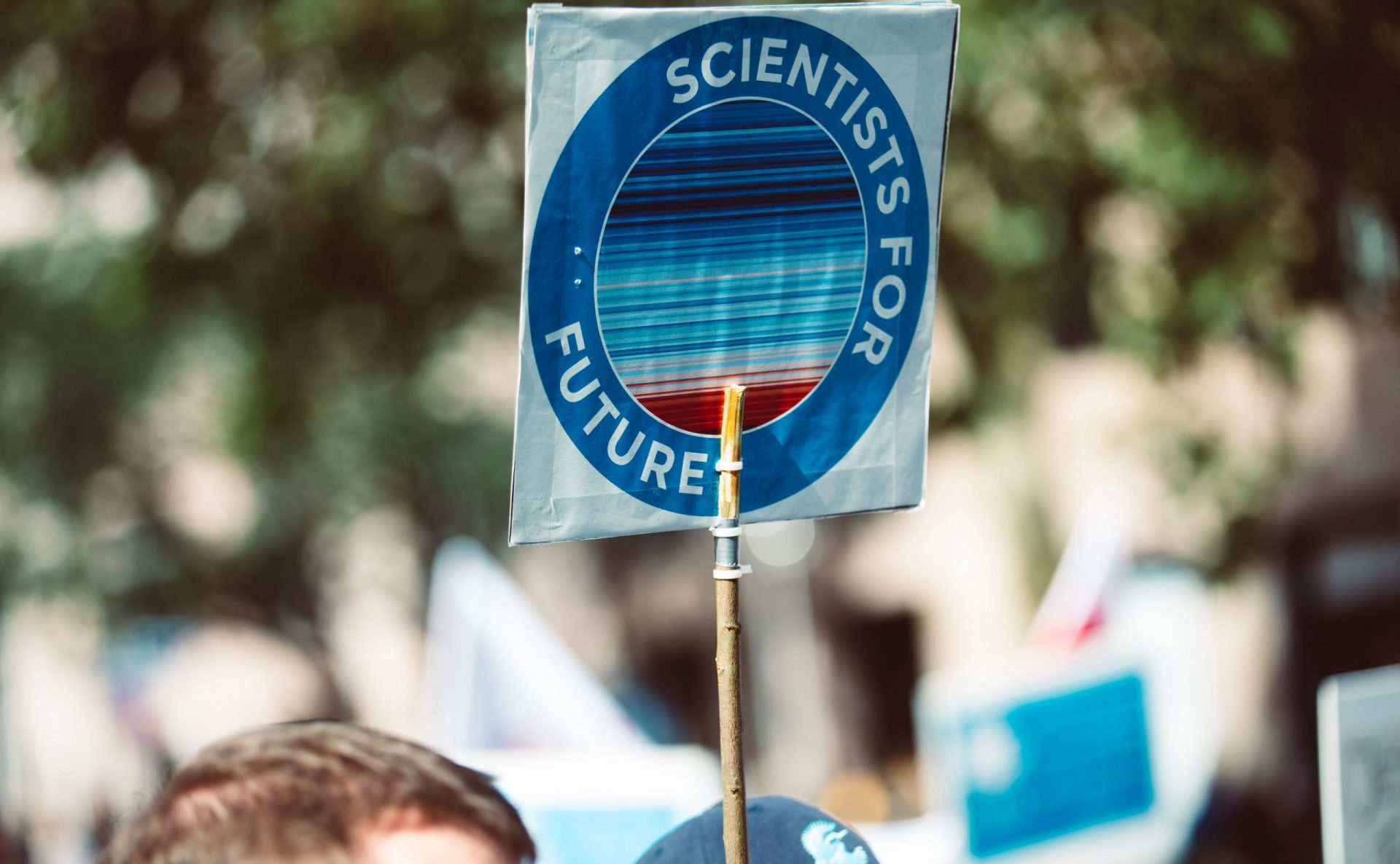 Man holding a Sign saying Scientists for Future in a protest