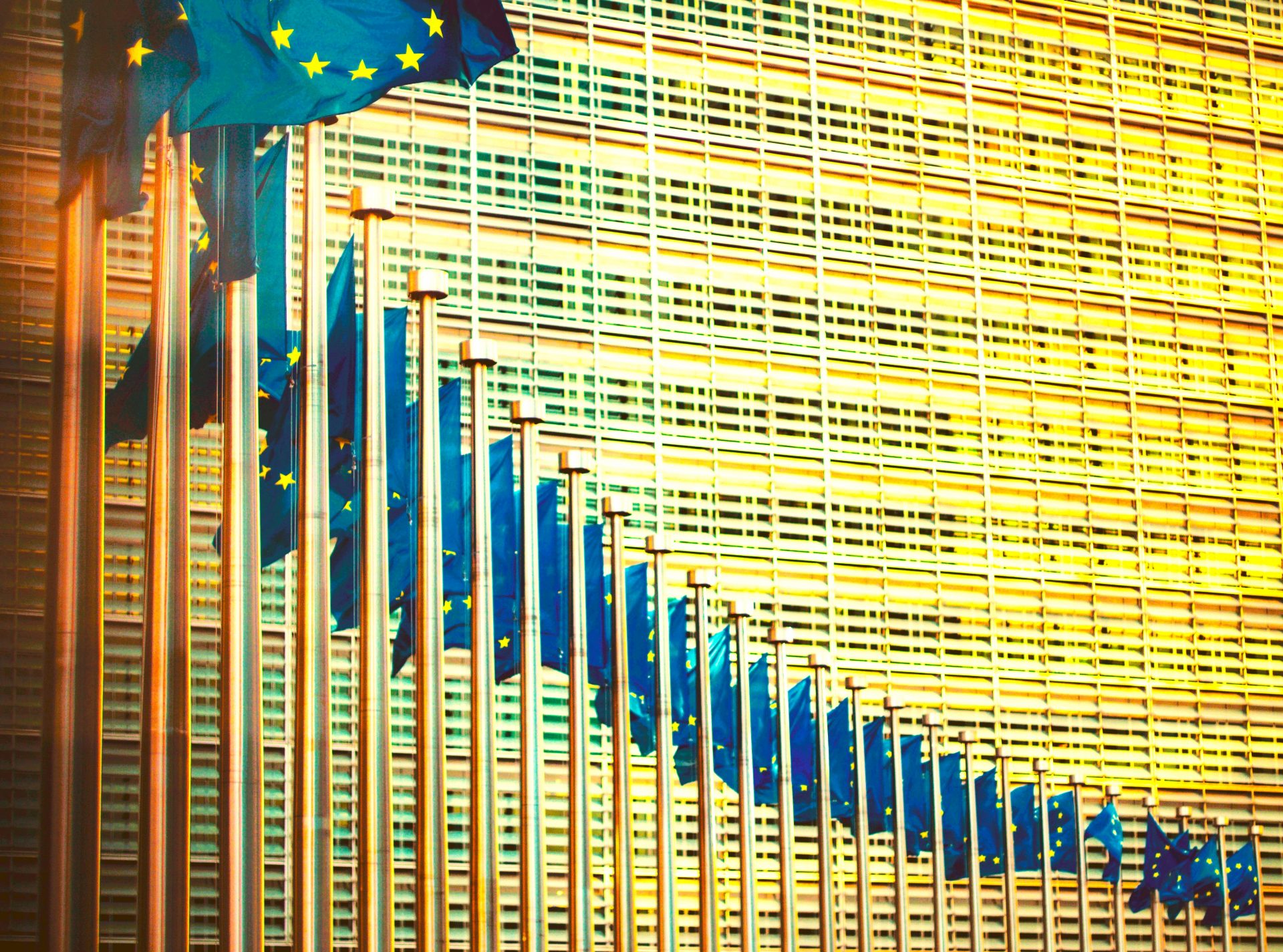 Warm picture of Berlaymont building with multiple hoisted European flags