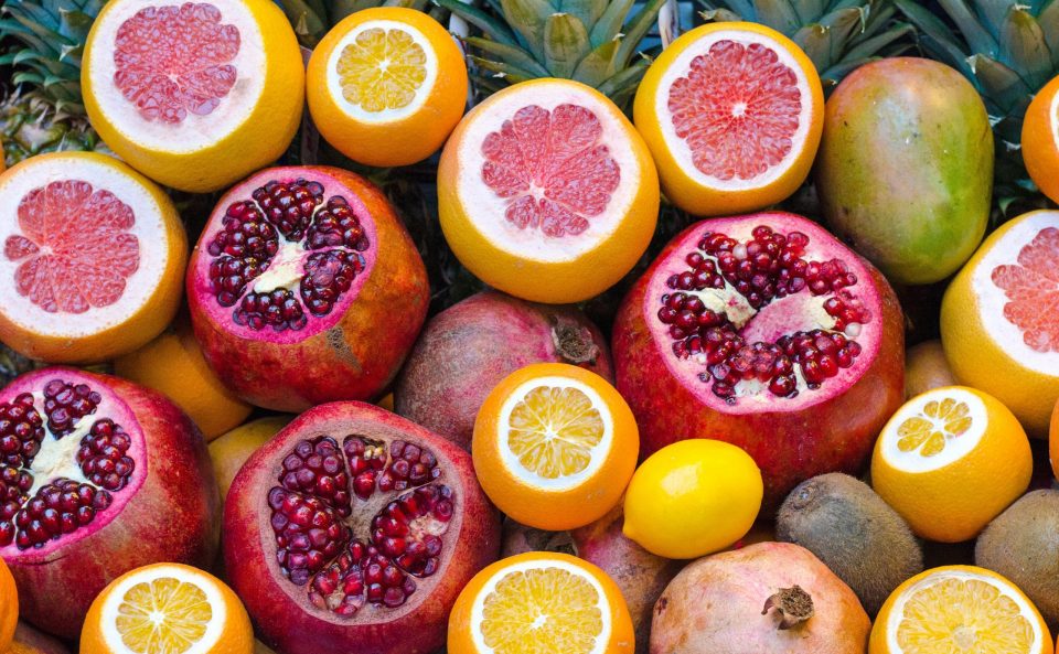 Image of multiple sliced oranges, mangos, Pomegranates, grapefruits, lemons